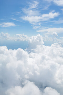 White, puffy clouds against a blue sky from an airplane