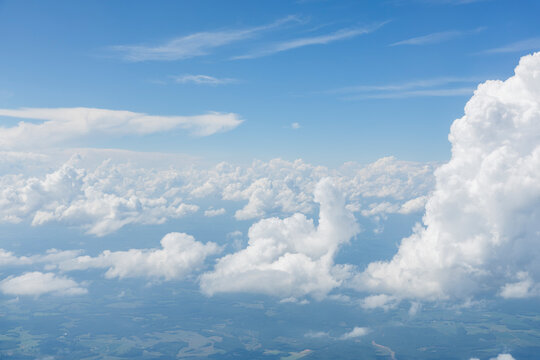 White, puffy clouds against a blue sky from an airplane