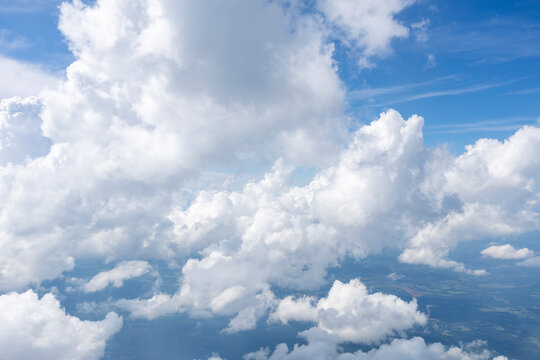 White, puffy clouds against a blue sky from an airplane