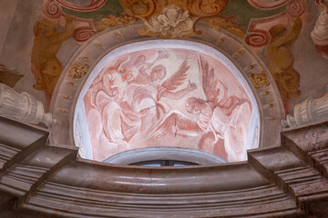 Naklejka premium A religious drawing of angels in a niche near a window in a chapel.
