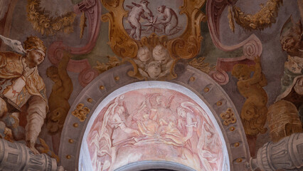 Naklejka premium A religious drawing of angels in a niche near a window in a chapel.