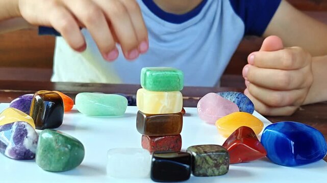 Studying minerals. Natural minerals in a child's hand. Multicolored semi-precious stones and minerals in close-up. Mineralogy. Mineral collection.