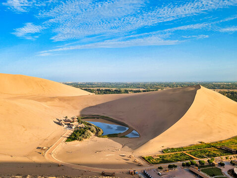 View of the Crescent Lake oasis nestled among the vast sand dunes of Mingsha Mountain in Jiuquan, China.