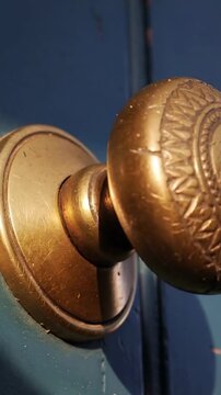 Vertical video: Panning camera starting clockwise, showing ornate brass knob crack on blue door