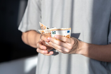 Hands holding and counting fifty euro banknotes