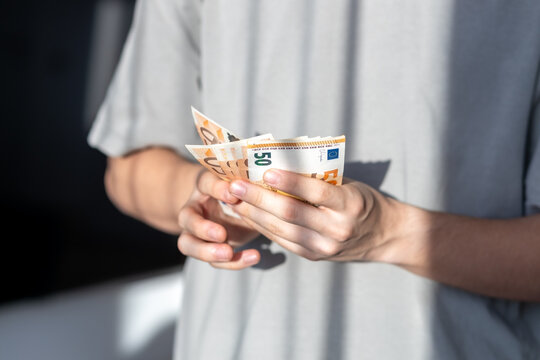 Hands holding and counting fifty euro banknotes