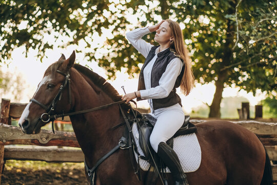 A young female jockey is sitting on her horse in show jumping training. Preparing for the competition.