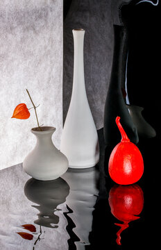 White vases with flowers and a red painted pumpkin
