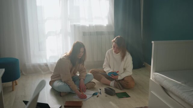 White coach and learner planning lesson in sunlit bedroom, notebooks and laptop open, grammar drills and curriculum notes, collaborative discussion, focused mentoring, creative strategy and goal
