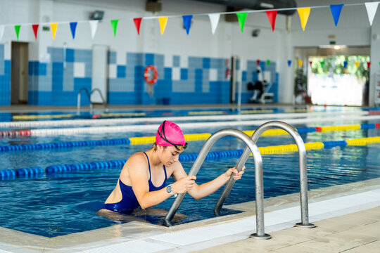 Female swimmer exiting pool, embodying discipline and self-improvement