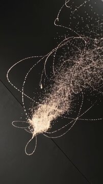 Vertical video: Light cue starting particle cloud forming filaments and brightening core at exhibit