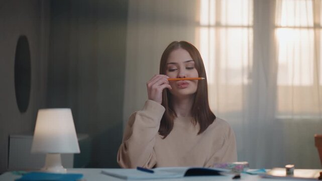 Caucasian woman balancing pencil playfully on upper lip, language coach role demonstrating pronunciation drills, open workbook and lamp on desk, gentle sunlight through curtain, amused expressions