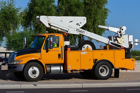 Municipal utility truck performing streetlight maintenance, illustrating roadway lighting service, electrical infrastructure, public works, and highway operations