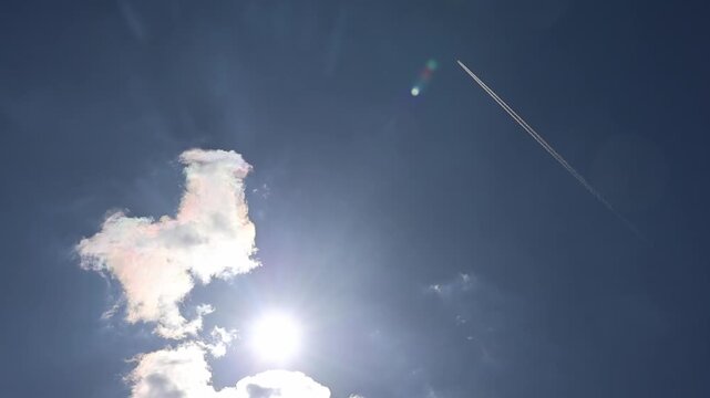 Airplane contrail crossing a bright sunny sky