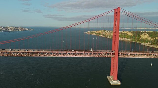 Panoramic aerial side view of the red 25 de Abril suspension bridge spanning the Tagus River between Lisbon and Almada, Portugal