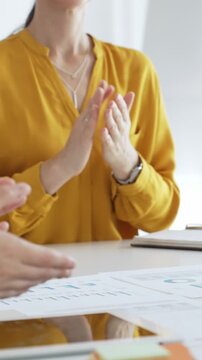 Business colleagues clapping hands after successful presentation or good news during a corporate meeting, celebrating achievement and success in office