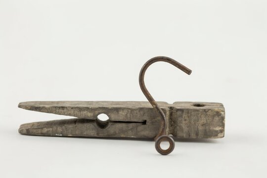 Vintage wooden clothespin with a metal hook isolated on white background
