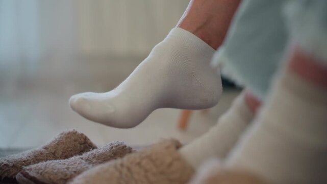 Focused domestic activity. Casual sock tapping session. Closeup of sock tapping as learner concentrates on task. Relaxed scene showing person tapping socks while studying on soft rug