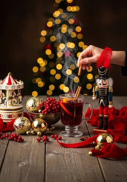 Steaming Spiced Wine Glass with Cinnamon Stick, Red Velvet Ribbon and Nutcracker for Elegant Christmas Menus
