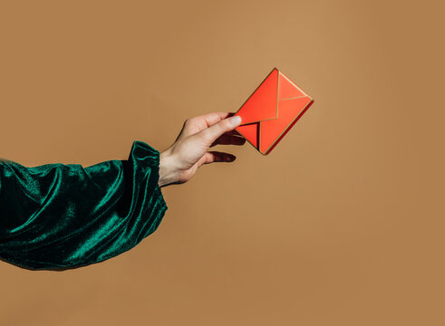 Hand holding bright red origami envelope gift