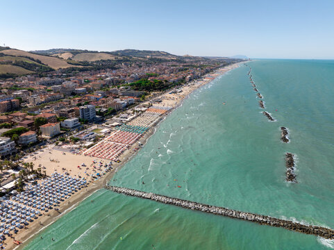 Aerial view of the sandy beach and rows of colorful umbrellas in the coastal town of Porto San Giorgio, Marche, Italy.