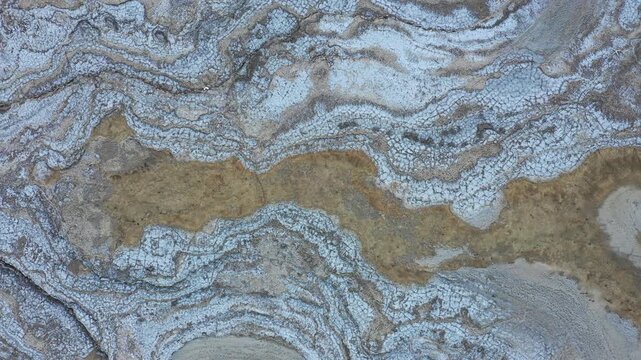 Aerial view of Dead Sea sinkholes showing intricate salt formations and textured terrain patterns in Beersheba, South District, Israel.