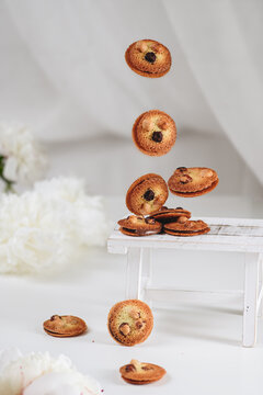 Butter cookies with nuts floating above white table