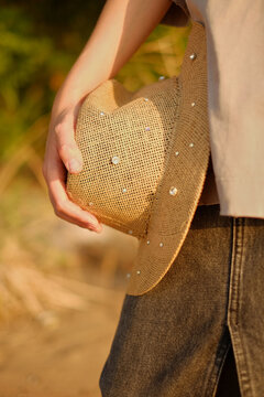 Woman hold straw hat during summer walk outdoors