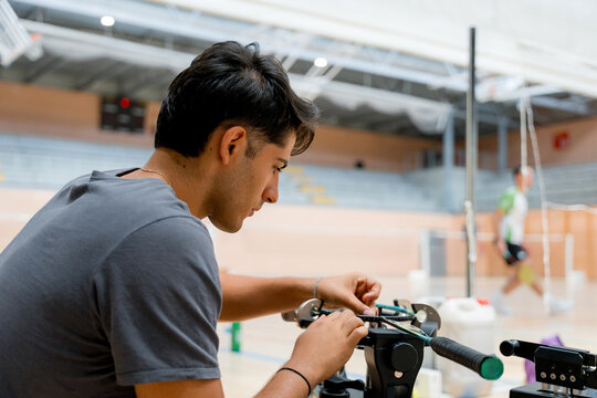 Man repair badminton racket at indoor sports court