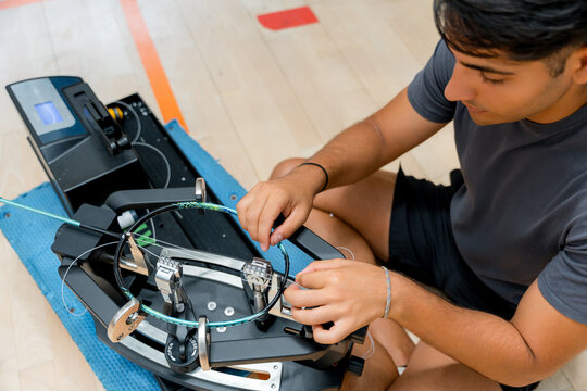 Man repair badminton racket with stringing machine