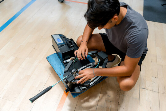 Man repair badminton racket on indoor court