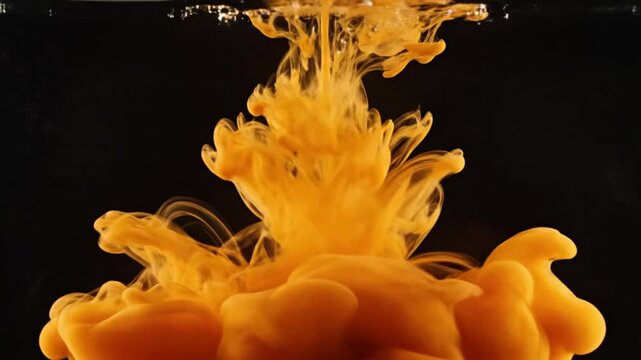 Vibrant yellow orange cloud of liquid forms; dynamic motion captured in dark water; suggests tropical elements and vivid energy