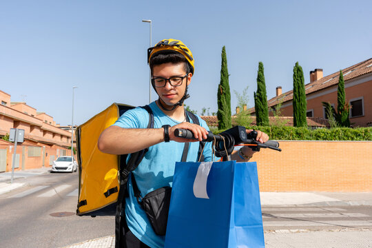 Scooter courier checking watch during urban delivery route