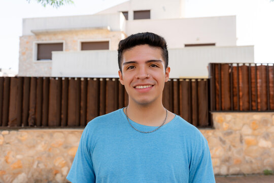 Smiling young man standing outside a modern home