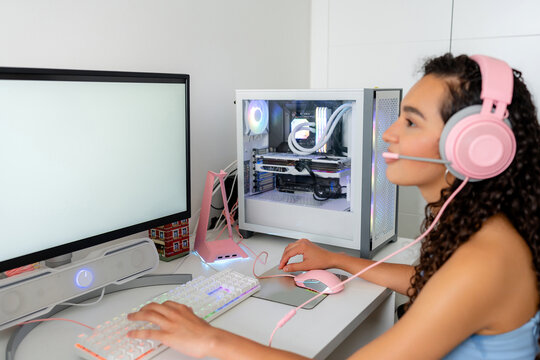 Young woman playing computer game at desktop setup