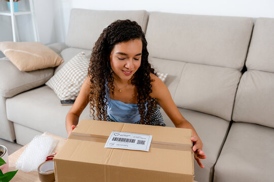 Young woman prepare sold parcel for online marketplace