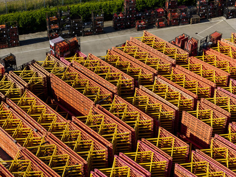 Aerial view of PERI Polska Sp. z o.o. facility showing organized rows of yellow and orange scaffolding frames stacked in an industrial storage yard, Jaworzno, Wojewodztwo slaskie, Poland.