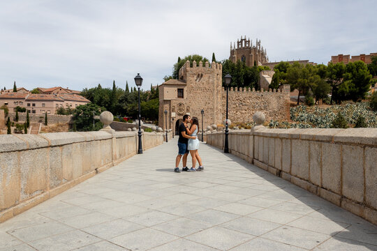 Couple embrace on San Martin Bridge in Toledo, Spain
