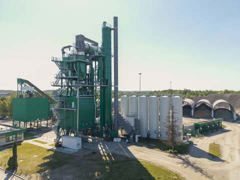 Aerial view of Masfalt Sp. z o.o. WMB asphalt plant with green industrial towers, storage silos, and gravel piles in Dabrowa Gornicza, Wojewodztwo slaskie, Poland.