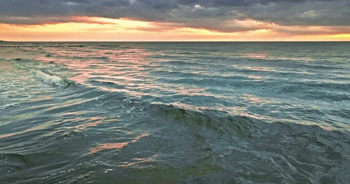 Stunning sea waves illuminated by sunset in Poland.