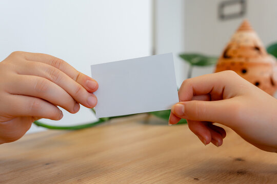 Hands exchanging blank card at modern clinic reception