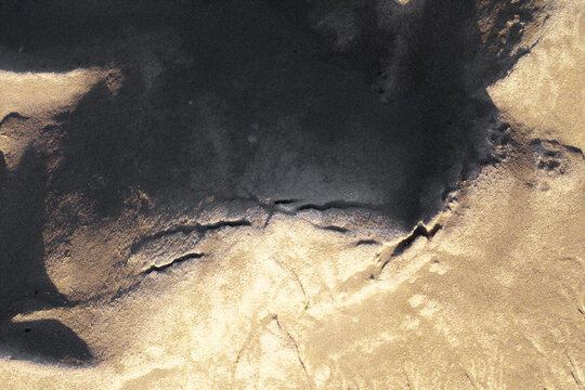 Aerial view of sandy surface with natural textures and deep shadows cast across the dunes Poland.