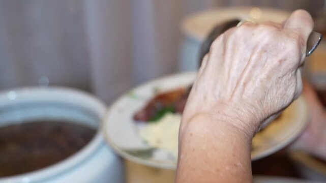 woman serving feijoada onto a plate, Brazilian food buffet