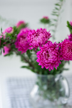 Pink chrysanthemum bouquet in glass vase with soft focus