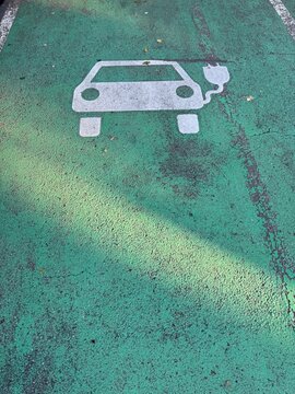 Green road with a car charging station on it