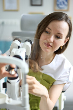 Female ophthalmologist holding lens during eye examination