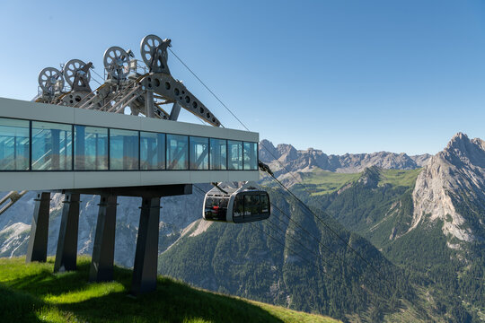 12 July 2026, Canazei, Italy. Cable car station and passenger gondola overlooking the Dolomites mountain landscape