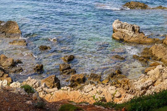 Rocky coastline with clear turquoise water gently lapping the shore