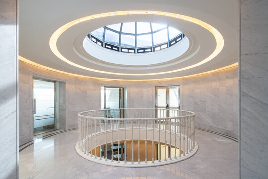 Neoclassical office atrium with circular skylight and railing