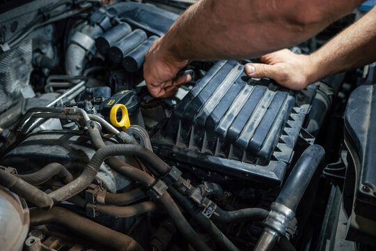 Car engine repair with mechanic hands performing diagnostics, inspection, servicing and preventive maintenance.